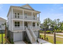 Stunning elevated two-story home featuring double porches, a two-car garage, and a beautifully landscaped yard at 1619 Cultivation Ln, Mount Pleasant, SC 29466