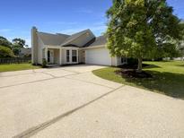 Charming single-story home featuring a well-manicured lawn, a spacious driveway, and an attached two-car garage at 1622 Pin Oak Cut, Mount Pleasant, SC 29466