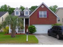 Charming two-story brick home with a well-manicured lawn and a palm tree in the front yard at 1757 Wayah Dr, Charleston, SC 29414