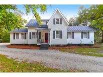 Charming white home with black shutters and a well-maintained gravel driveway at 205 Tea Farm Rd, Summerville, SC 29483
