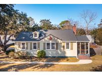 Charming home featuring light yellow siding, gray shingles, a brick chimney, and a cozy screened in porch at 2178 Fort Pemberton Dr, Charleston, SC 29412