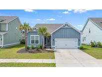 Charming single-Gathering home with two palm trees, an attached two-car garage, and beautiful blue siding at 221 Seaworthy St, Summerville, SC 29486