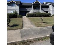 Attractive condominium exterior featuring multiple stories, well-maintained landscaping, and inviting entry stairs at 2502 Hidden Cove Dr # 2502, Moncks Corner, SC 29461