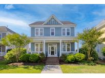 Charming two-story home with a welcoming front porch and well-manicured landscaping at 311 Amaryllis Ave, Summerville, SC 29483