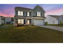 Charming two-story home features a manicured lawn, brick accents, and a two-car garage at 433 Thoroughbred Dr, Moncks Corner, SC 29461