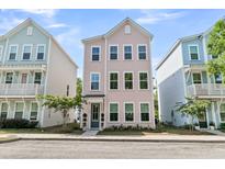 Charming three-story home with a pastel pink exterior and manicured front yard, flanked by similar homes at 4429 Avery Ave, North Charleston, SC 29405