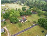 Expansive property with a cozy home, lush greenery, and a serene pond in a tranquil neighborhood at 449 Mary Lou Ln, Moncks Corner, SC 29461