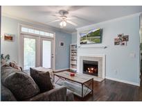 Inviting living room featuring a cozy fireplace, ceiling fan, and access to the outdoor balcony at 45 Sycamore Ave # 1532, Charleston, SC 29407