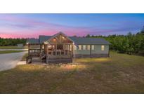 Charming home featuring a screened-in porch and views of the landscaped yard at 5653 Wire Rd, Branchville, SC 29432