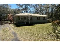 Charming single-story home with a well-maintained lawn and a metal roof at 6086 Chisolm, Johns Island, SC 29455