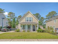 Charming two-story home featuring a well-manicured lawn and a welcoming front porch, exuding curb appeal in a serene neighborhood at 7414 Purser Ln, Hanahan, SC 29410