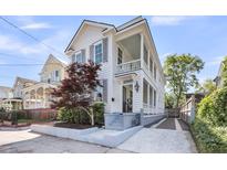 Charming two-story home with a covered porch, beautiful landscaping, and a driveway at 103 Fishburne St, Charleston, SC 29403