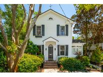 Charming two-story home with black shutters, beautiful landscaping, and a brick walkway leading to the front door at 135 Beaufain St, Charleston, SC 29401