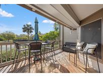 Inviting patio with seating area and outdoor umbrella overlooking lush greenery and blue skies at 1619 Live Oak Park, Johns Island, SC 29455