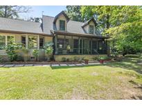 Charming home featuring a screened-in porch and a beautifully landscaped front yard, ideal for outdoor enjoyment at 2144 Pinopolis Rd, Pinopolis, SC 29469