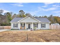 Charming single-story home with a welcoming front porch and rocking chairs at 255 S Railroad Ave, Ridgeville, SC 29472