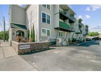 Apartment building with gray siding, black iron balconies and parking lot at 259 E Bay St # 7C, Charleston, SC 29401
