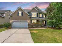 Charming two-story home with a manicured lawn, attached garage, and inviting front porch at 3025 Buckeley Cir, Charleston, SC 29414