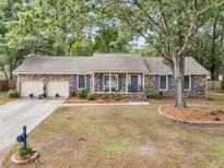 Charming brick home with blue shutters, attached garage, and mature landscaping at 31 Monte Sano Dr, Hanahan, SC 29410