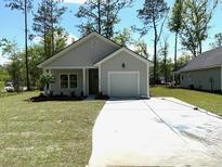 Charming single-story home featuring a well-manicured lawn and a convenient attached garage at 3214 Pinewood Dr, Ladson, SC 29456