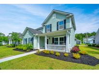 Charming two-story home with a covered front porch, manicured landscaping, and light teal siding at 3941 Bessemer Rd, Mount Pleasant, SC 29466