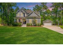 Beautiful two-story home with a manicured lawn, gray siding, and a detached two-car garage at 474 Woodspring Rd, Mount Pleasant, SC 29466
