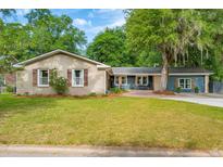 Charming single-story home featuring a brick facade, shutters, and a well-manicured lawn at 5 S Basilica Ave, Hanahan, SC 29410