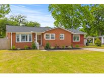 Charming brick home with a well-manicured lawn and landscaping at 5163 W Dolphin St, North Charleston, SC 29405