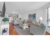 Bright living room featuring hardwood floors, comfortable seating, and an open layout connecting to the kitchen at 8000 Palmetto Dr # 104-A, Isle of Palms, SC 29451