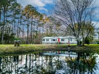 Charming home featuring a pond and lush greenery at 107 Bessie Ln, Bonneau, SC 29431