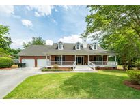 Charming brick home with a large front porch and well-manicured lawn creating inviting curb appeal at 1100 Cass Dr, Moncks Corner, SC 29461