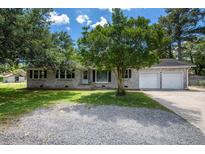 Charming brick home with a well-maintained yard and a two-car garage on a sunny day at 115 Myers Rd, Summerville, SC 29486