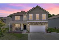 Charming two-story home featuring stone accents, a covered porch, and a two-car garage at 118 Beacon Falls Ct, Summerville, SC 29486