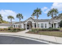 Beautiful clubhouse entrance featuring palm trees, well-kept landscaping, and architectural roof detail at 1300 Park West Blvd # 811, Mount Pleasant, SC 29466