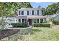 Charming two-story home with a welcoming front porch and manicured landscaping, located on a tree-lined street at 1938 Oak Tree Ln, Mount Pleasant, SC 29464