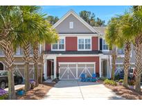 Charming two-story townhome featuring a garage, front yard landscaping, and a driveway with blue chairs at 1992 Kings Gate Ln, Mount Pleasant, SC 29466