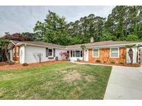 Charming single-story home with a manicured lawn, brick and wood exterior, and mature trees at 203 Red Fox Run, Summerville, SC 29485