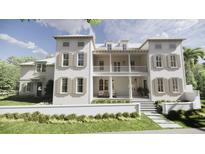 Elegant two-story home with a charming balcony, shutters, and a well-manicured lawn on a sunny day at 33 Duany Rd, Mount Pleasant, SC 29464