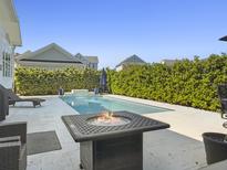 Relaxing backyard pool with a fire pit and plenty of lounge area with lush hedges for privacy at 3608 Maidstone Dr, Mount Pleasant, SC 29466