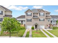 Charming townhome featuring a two car garage, well-maintained lawn, and inviting front entrance at 4209 Climbing Tree Ct, Charleston, SC 29414