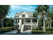 Charming two-story beach home with a double garage, white siding and a welcoming front porch at 5005 Saltspray Ln, Johns Island, SC 29455