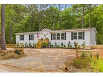 Charming single-story home with a beautiful landscaped yard and inviting wooden stairway and an American flag at 637 Murphy Bay Dr, Cross, SC 29436
