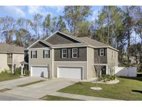 Charming townhome featuring a two-car garage, landscaped yard, and neutral-toned siding that provides a welcoming curb appeal at 116 Bright Meadow Rd, Summerville, SC 29483