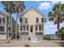 Charming two-story beach home with double garages, central stairway, and palm trees at 126 W 2Nd St, Folly Beach, SC 29439