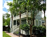 Charming home featuring double porches, palm trees, and beautiful landscaping at 133 Wando Reach Rd, Wando, SC 29492