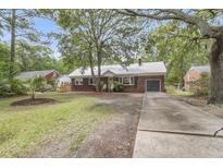 Charming brick home with a metal roof, well-maintained landscaping, and long concrete driveway at 1534 Salisbury St, Charleston, SC 29407