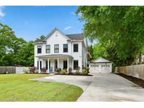 Inviting two-story farmhouse-style home with a charming front porch and well-manicured lawn, showcasing classic American architecture at 1872 Rifle Range Rd, Mount Pleasant, SC 29464