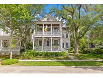 Charming two-story home featuring double porches, mature trees, and lush landscaping at 225 Delahow St, Daniel Island, SC 29492