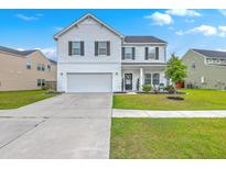Charming two-story home with a well-manicured lawn, attached garage, and classic white siding at 306 Lucca Dr, Summerville, SC 29486