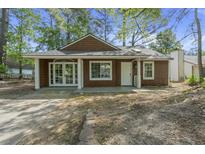 Charming single-story home with brown wood shingles, and a well-manicured front yard at 335 Macgregor Dr, Summerville, SC 29486